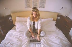 Vrouw met laptop in bed