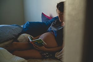 Zwangere vrouw leest in bed
