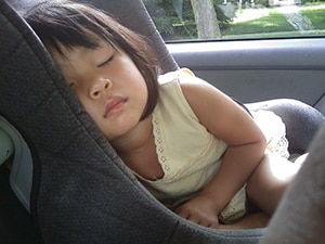 Kind slaapt in de auto